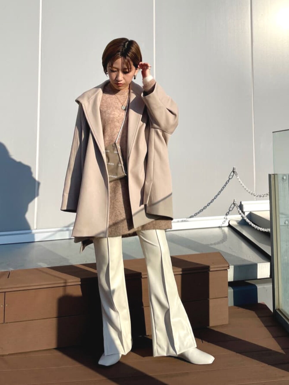 ホワイト系のその他アウター、ベージュ系のニット/セーター、ベージュ系のショルダーバッグを着用したレディースの春コーディネートの2枚目の写真