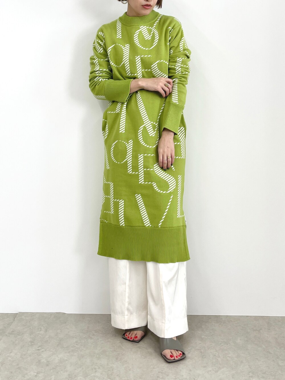 グリーン系のワンピース、ホワイト系のその他パンツを着用したレディースの冬コーディネートの2枚目の写真