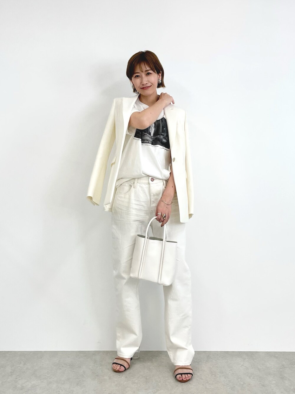 ホワイト系のテーラードジャケット、ホワイト系のその他パンツ、ホワイト系のハンドバッグを着用したレディースの春コーディネートの2枚目の写真