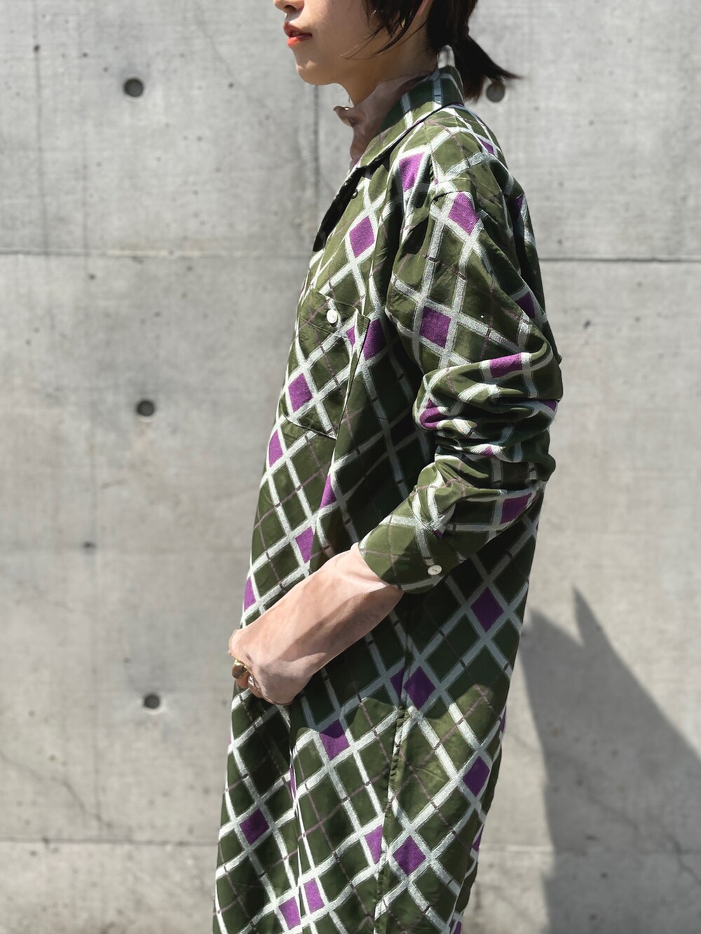 ベージュ系のTシャツ/カットソー、グリーン系のシャツワンピース、ブラック系のブーツを着用したレディースの秋コーディネートの2枚目の写真