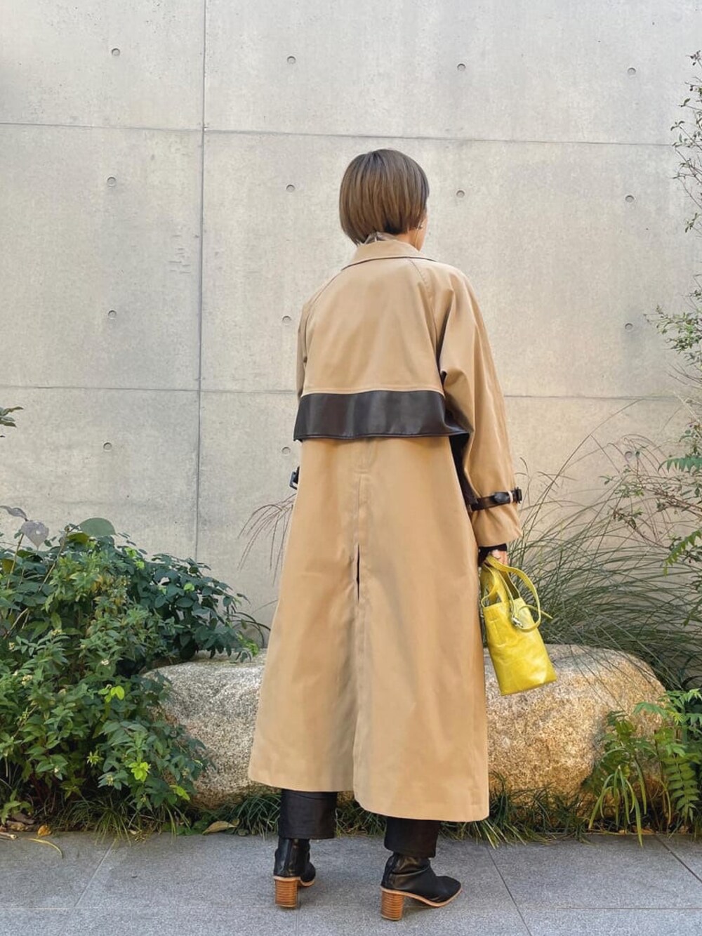 ベージュ系のトレンチコート、グレー系のTシャツ/カットソー、ブルー系のニット/セーターを着用したレディースの春コーディネートの3枚目の写真