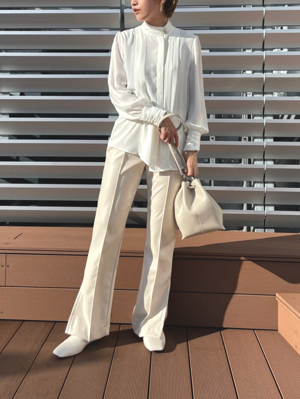 ホワイト系のシャツ/ブラウス、ホワイト系のバッグ、ホワイト系のその他パンツを着用したレディースの冬コーディネートの2枚目の写真