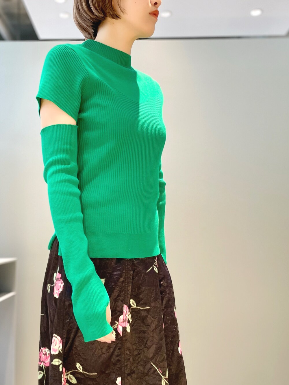 グリーン系のニット/セーター、ブラック系のシューズ、ブラック系のスカートを着用したレディースの春コーディネートの2枚目の写真