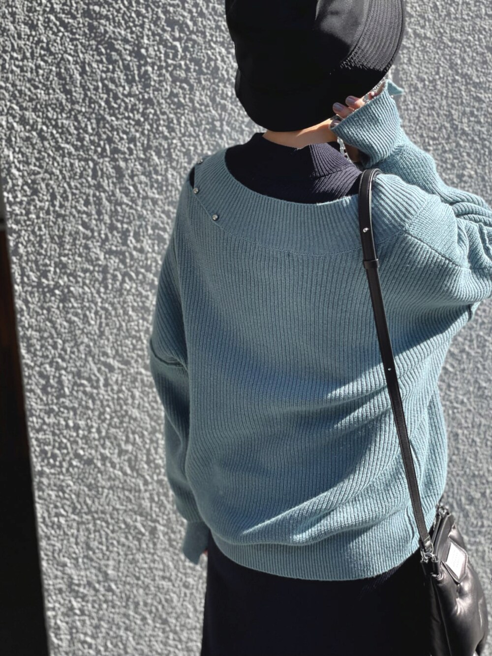 ブルー系のニット/セーター、ブルー系のワンピース、ブラック系のショルダーバッグを着用したレディースの春コーディネートの4枚目の写真