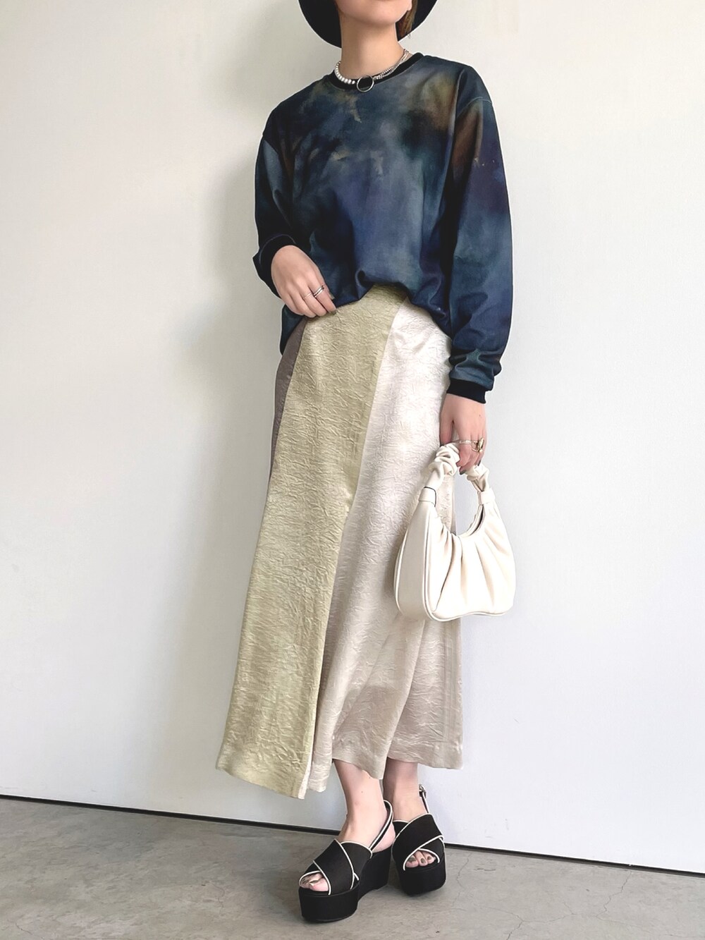 ブルー系のTシャツ/カットソー、グリーン系のスカート、ブラック系のサンダルを着用したレディースの春コーディネートの2枚目の写真