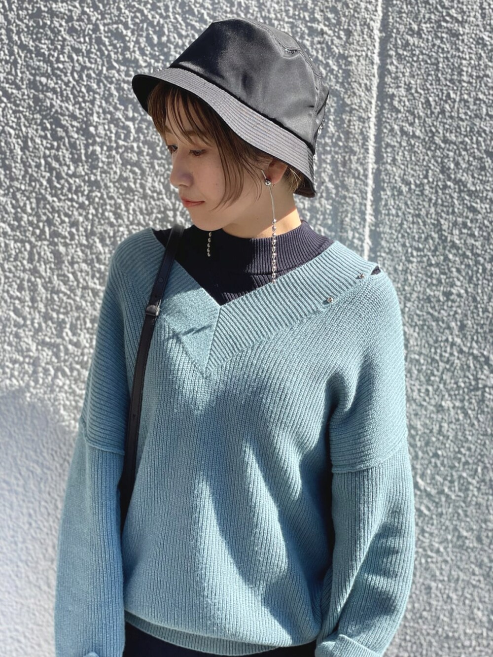 ブルー系のニット/セーター、ブルー系のワンピース、ブラック系のショルダーバッグを着用したレディースの春コーディネートの3枚目の写真