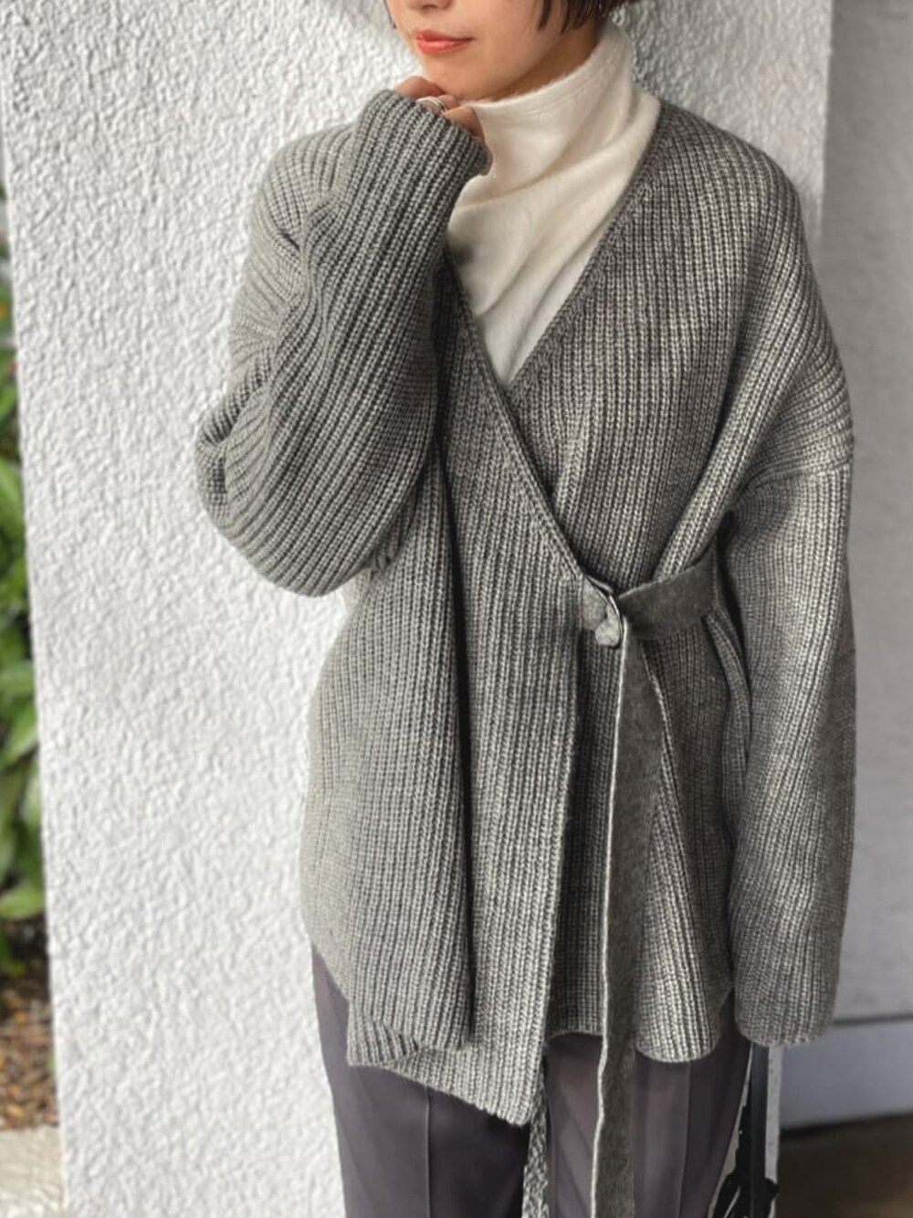 ブラック系のダウンジャケット/コート、グリーン系のニット/セーターを着用したレディースの秋コーディネートの2枚目の写真