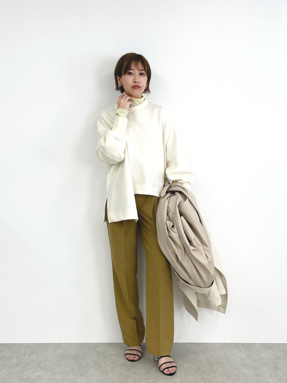 ベージュ系のトレンチコート、イエロー系のその他トップス、イエロー系のその他パンツを着用したレディースの春コーディネートの3枚目の写真