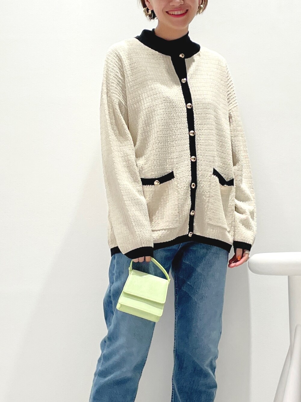 ホワイト系のカーディガン/ボレロ、ブラック系のその他トップス、ブルー系のデニムパンツを着用したレディースの秋コーディネートの2枚目の写真