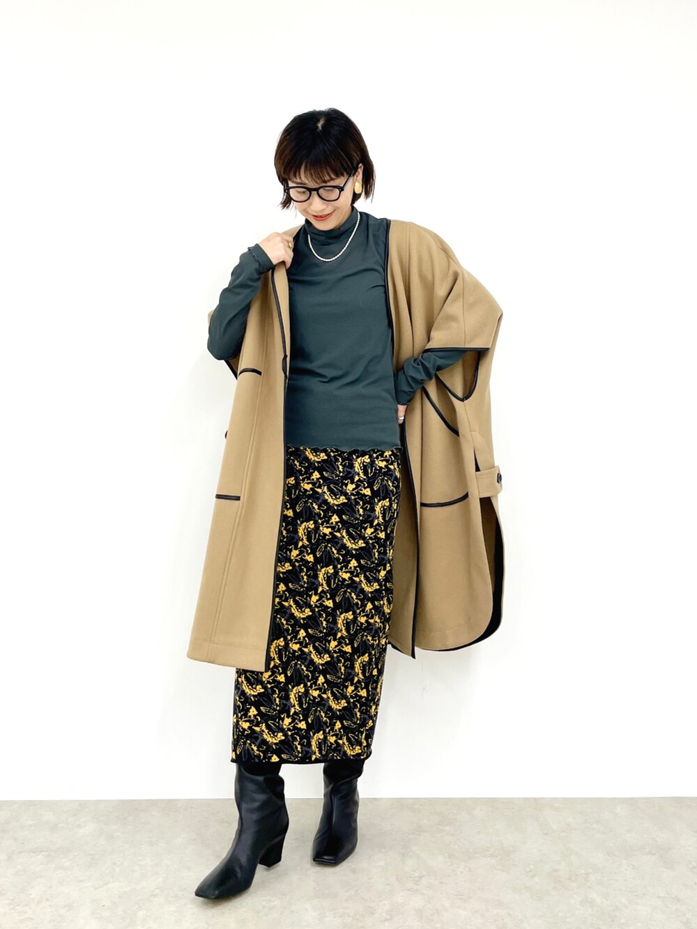 ベージュ系のその他アウター、グリーン系のTシャツ/カットソー、ブラック系のスカートを着用したレディースの秋コーディネートの3枚目の写真