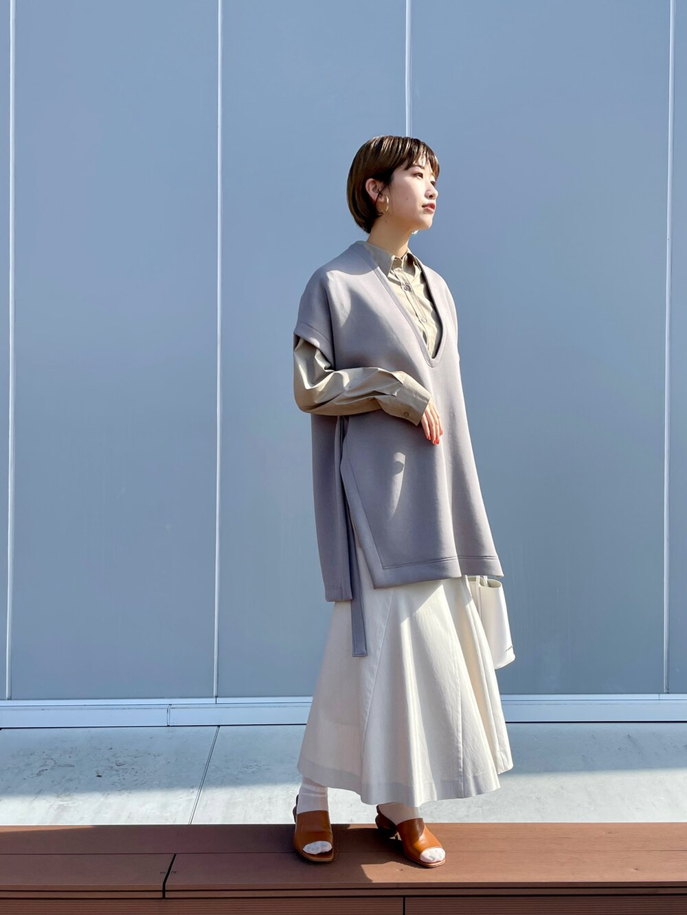 ベージュ系のベスト、ベージュ系のシャツ/ブラウス、ホワイト系のハンドバッグを着用したレディースの春コーディネートの2枚目の写真