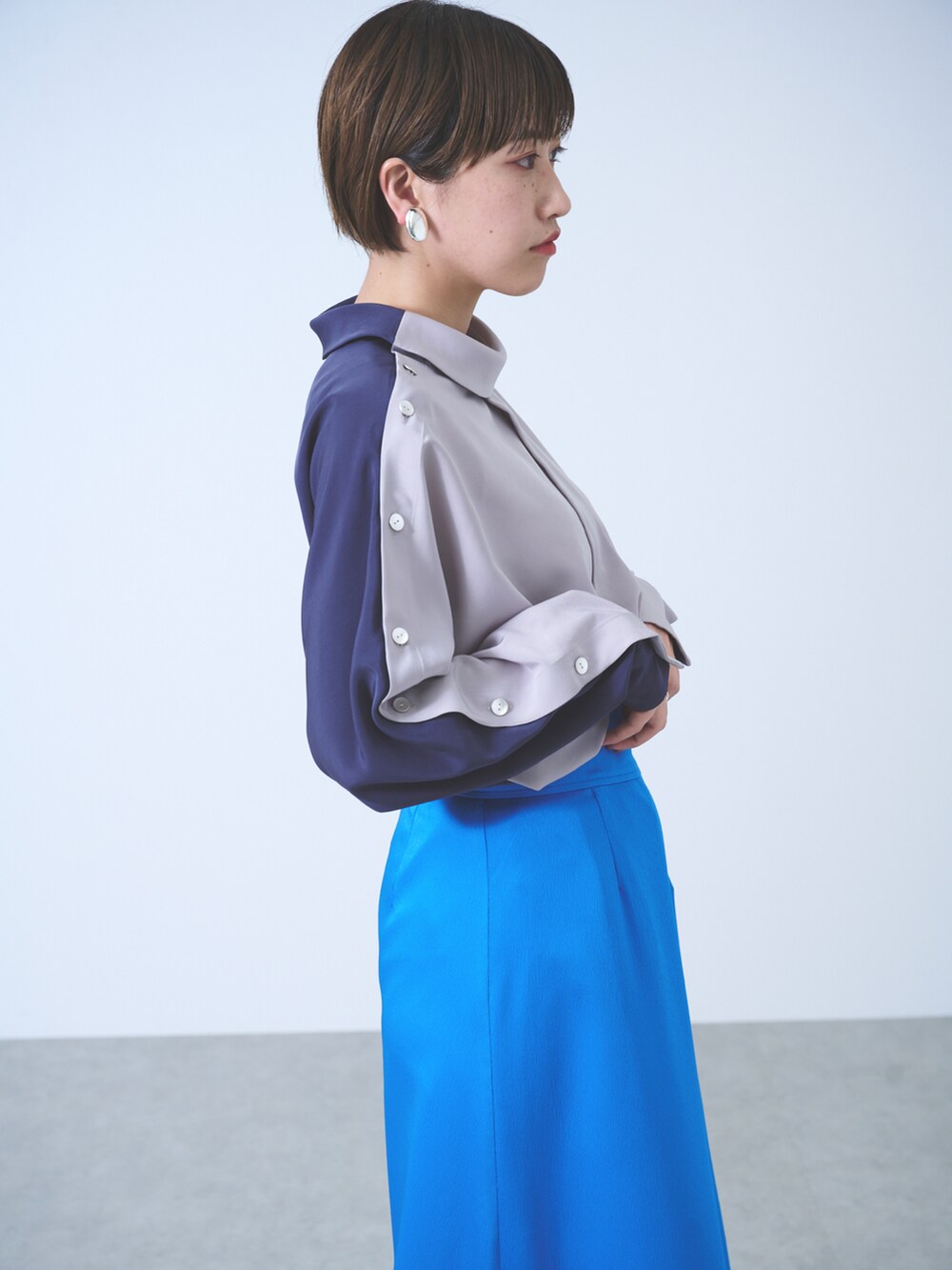 グレー系のシャツ/ブラウス、ブルー系のスカート、ブラック系のサンダルを着用したレディースの秋コーディネートの2枚目の写真