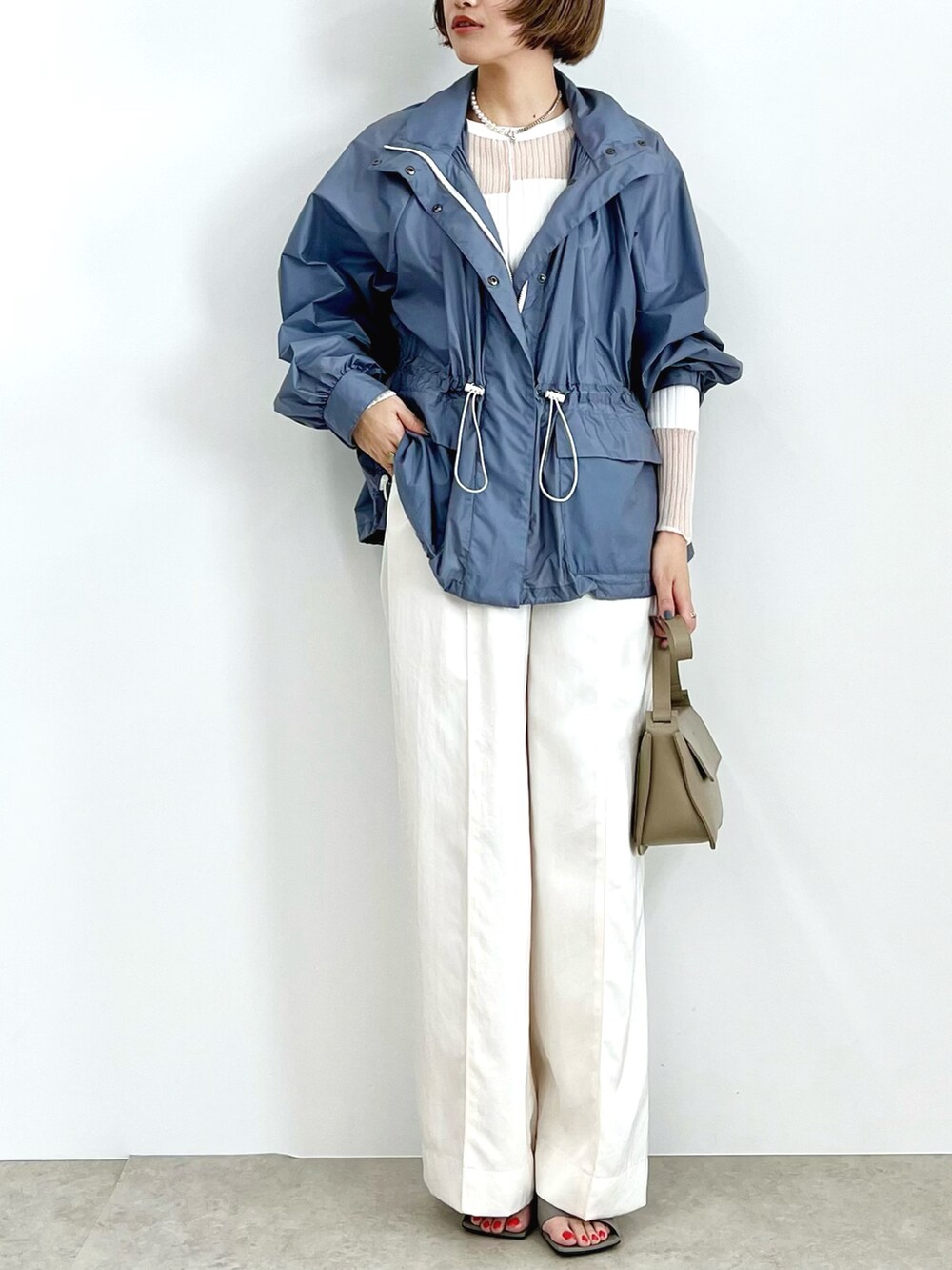ブルー系のブルゾン、ホワイト系のその他パンツを着用したレディースの冬コーディネートの2枚目の写真