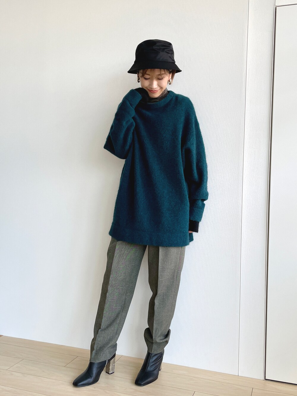 グリーン系のニット/セーター、グリーン系のその他トップス、グレー系のスラックスを着用したレディースの春コーディネートの2枚目の写真
