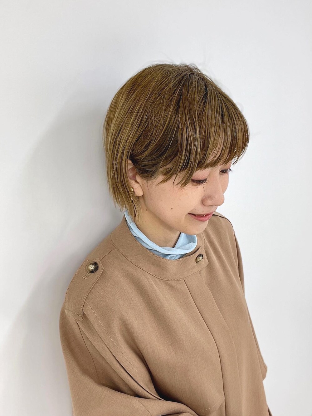 ベージュ系のポンチョ、ブルー系のその他トップス、ブラック系のその他パンツを着用したレディースの春コーディネートの4枚目の写真