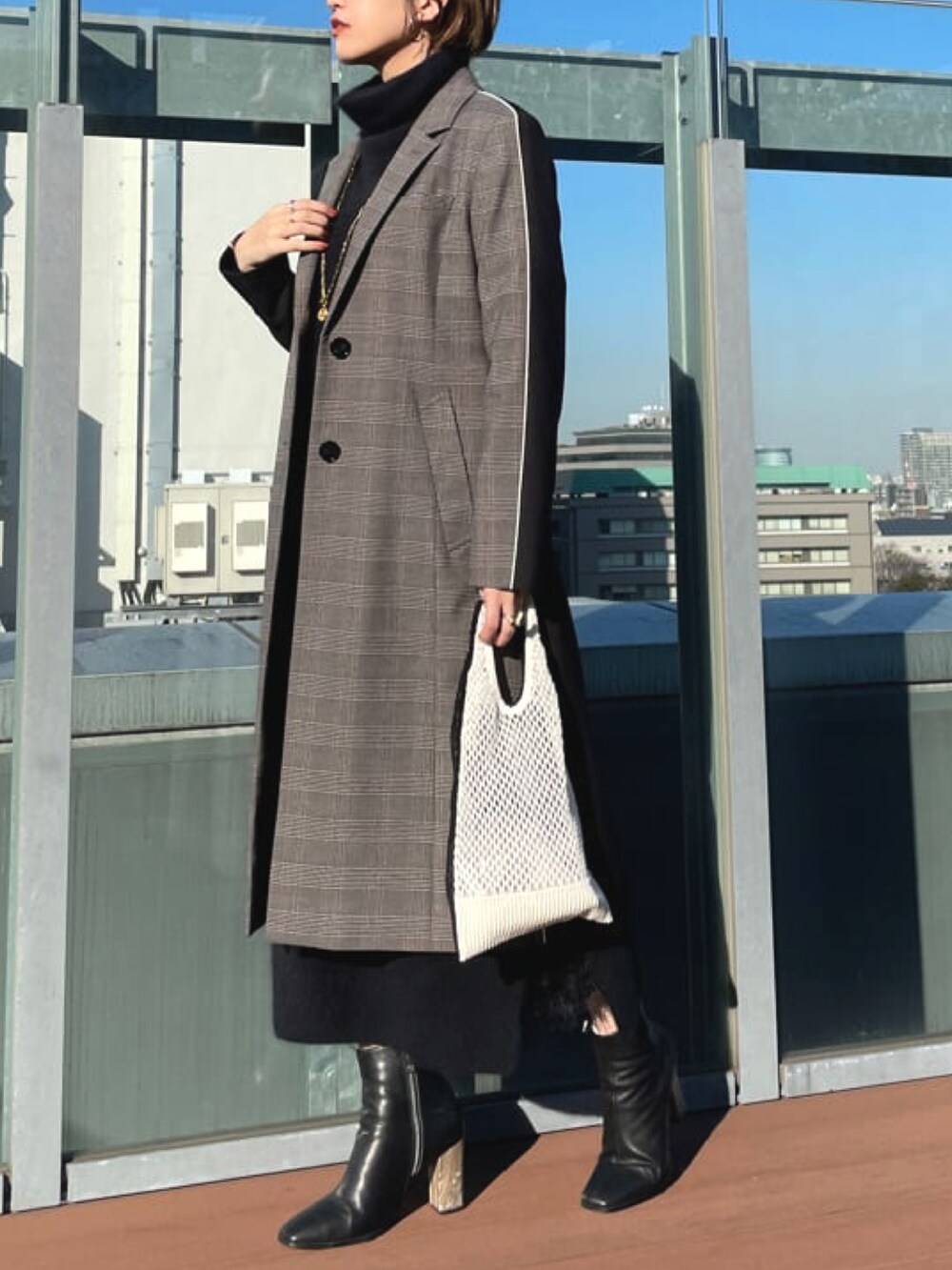グレー系のチェスターコートを着用したレディースの秋コーディネートの3枚目の写真
