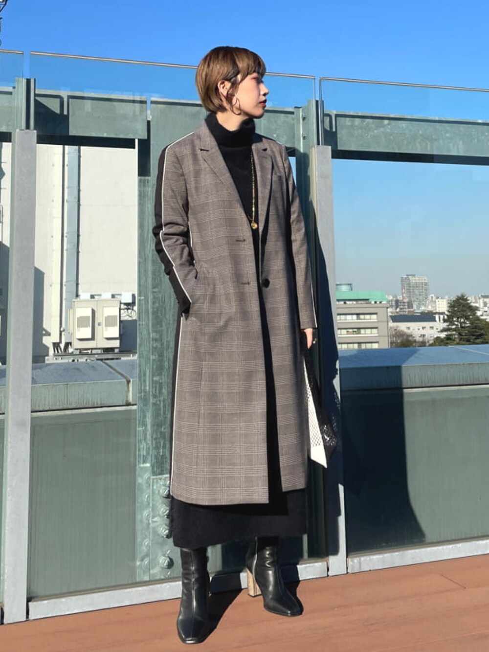 グレー系のチェスターコートを着用したレディースの秋コーディネートの2枚目の写真