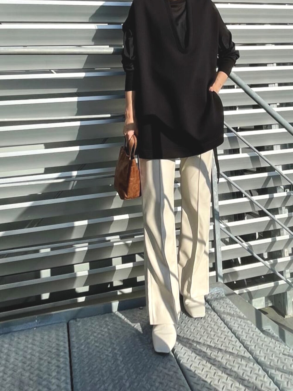 ブラック系のベスト、ブラック系のその他トップス、ホワイト系のその他パンツを着用したレディースの冬コーディネートの2枚目の写真