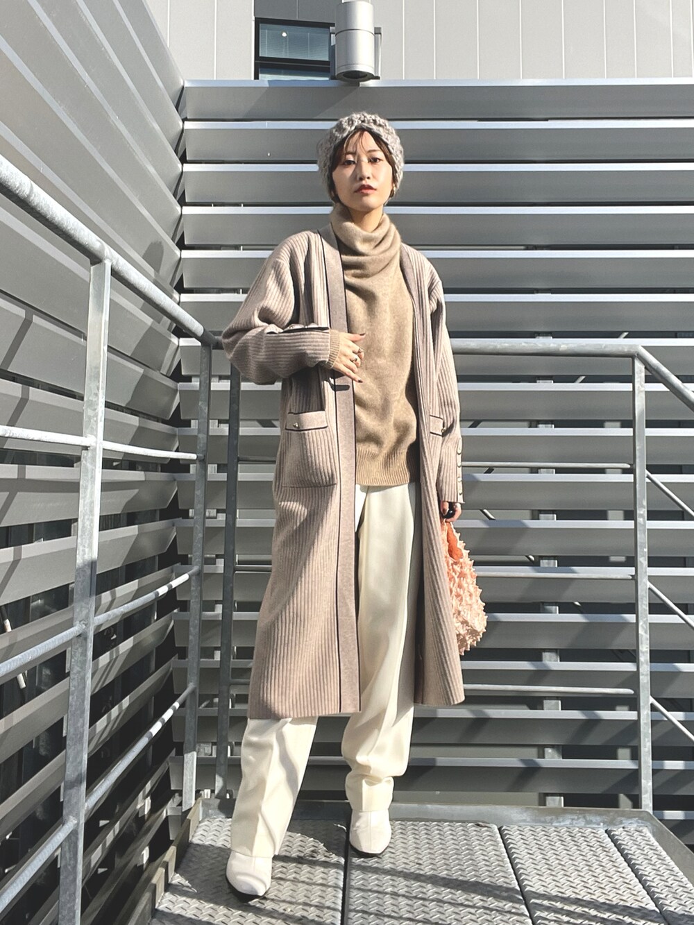 ベージュ系のカーディガン/ボレロ、ベージュ系のニット/セーター、ベージュ系のエコバッグ/サブバッグを着用したレディースの春コーディネートの2枚目の写真