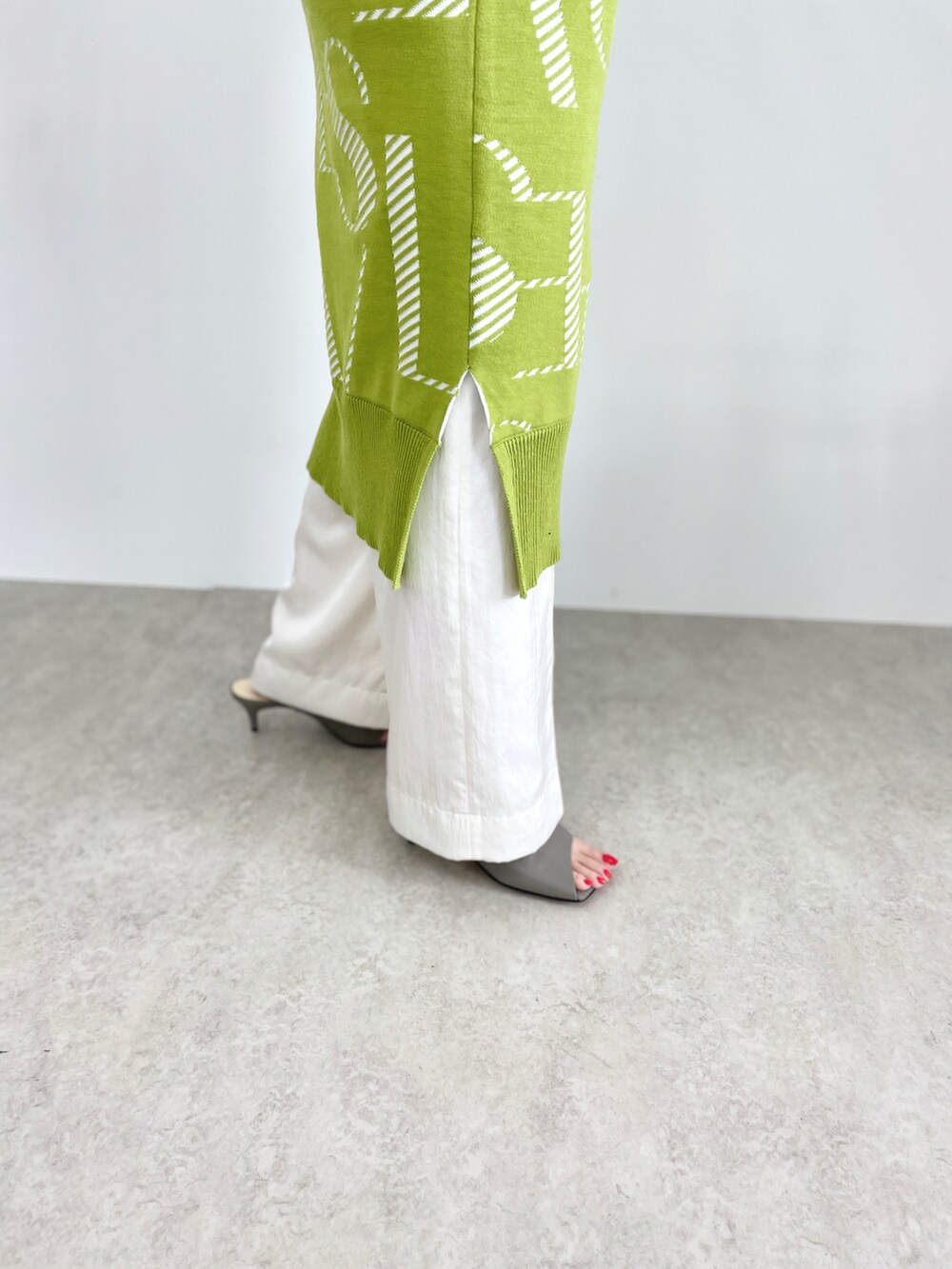 グリーン系のワンピース、ホワイト系のその他パンツを着用したレディースの冬コーディネートの3枚目の写真