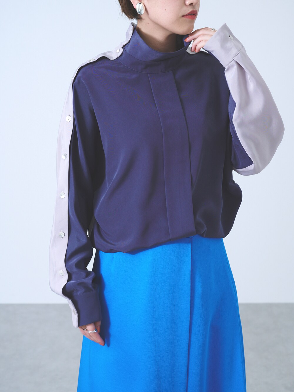 グレー系のシャツ/ブラウス、ブルー系のスカート、ブラック系のサンダルを着用したレディースの秋コーディネートの3枚目の写真