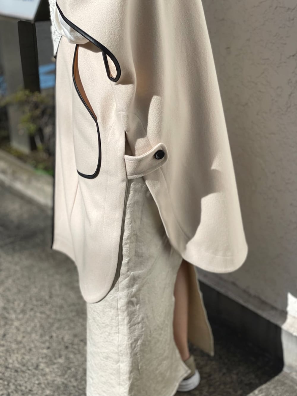 ホワイト系のその他アウター、ホワイト系のニット/セーター、ホワイト系のスカートを着用したレディースの春コーディネートの3枚目の写真