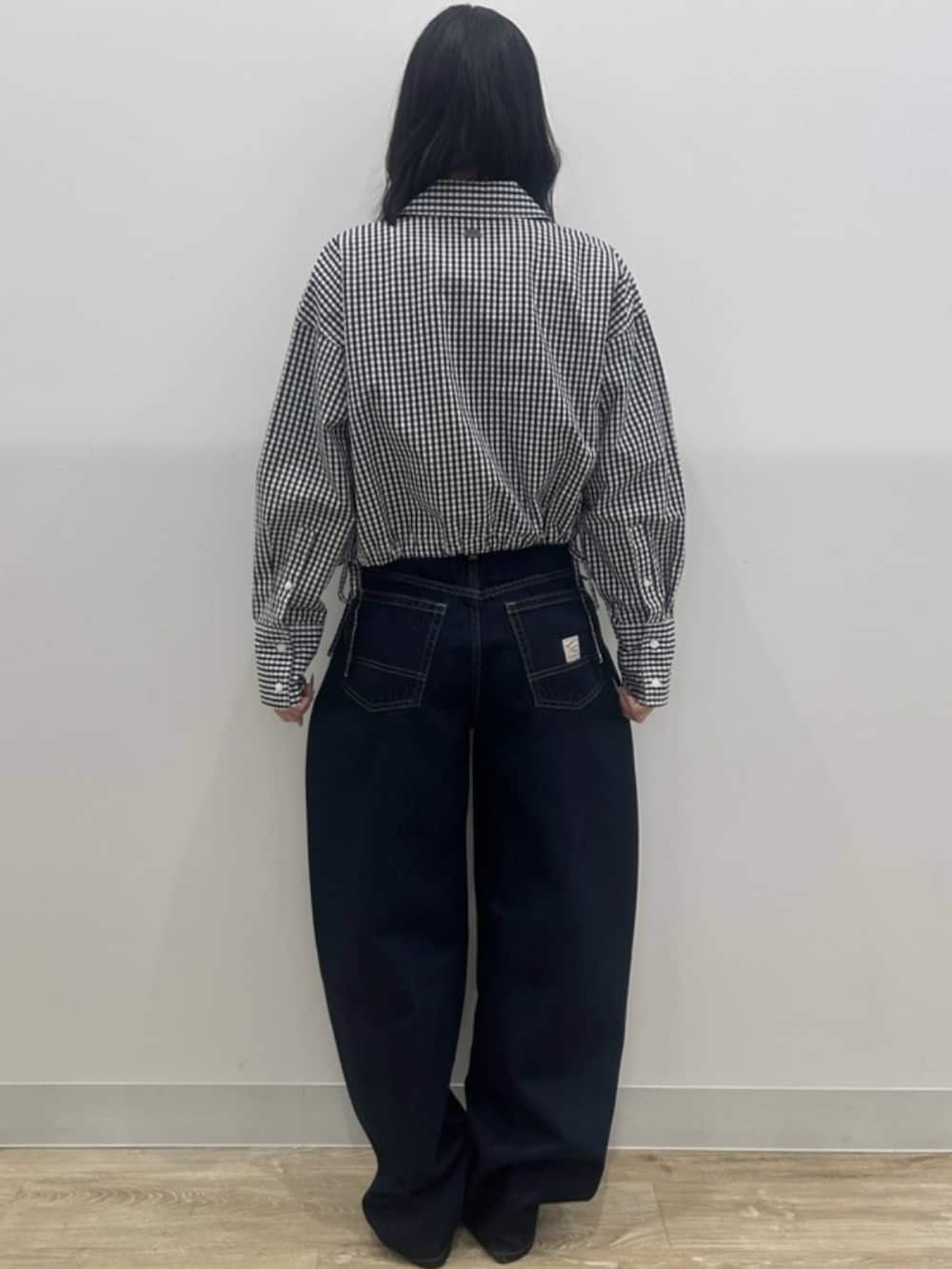 ホワイト系のTシャツ/カットソー、ブラック系のシャツ/ブラウス、ブルー系のデニムパンツを着用したレディースの冬コーディネートの2枚目の写真