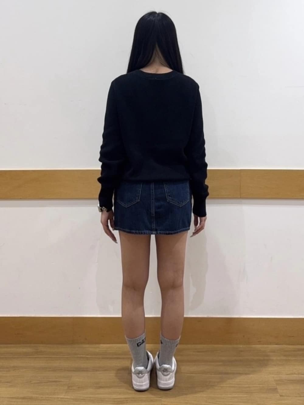 ブルー系のデニムスカート、ブラック系のニット/セーターを着用したレディースの夏コーディネートの2枚目の写真