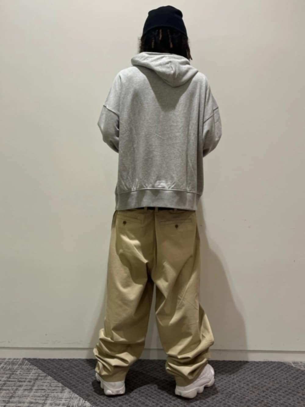 グレー系のパーカー、ベージュ系のチノパンツを着用したメンズの夏コーディネートの2枚目の写真