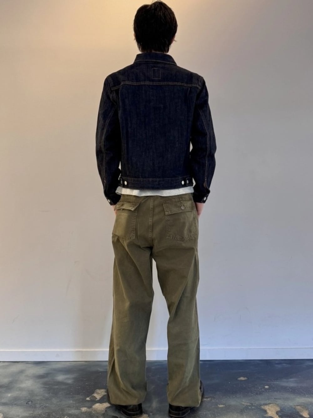 ブルー系のデニムジャケット、グリーン系のデニムパンツ、グレー系のTシャツ/カットソーを着用したメンズの秋コーディネートの2枚目の写真