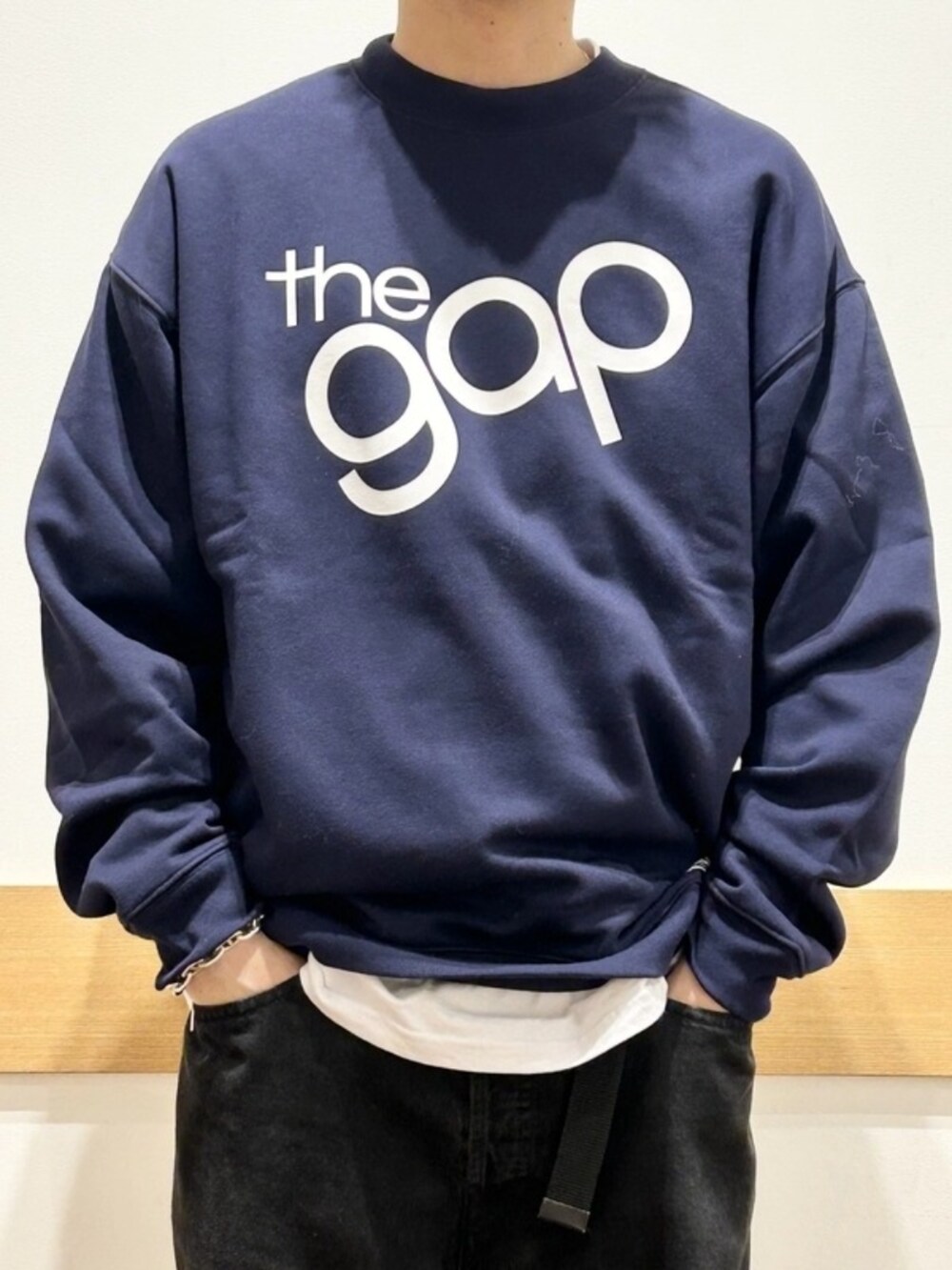 ホワイト系のTシャツ/カットソー、ブルー系のスウェット、ブラック系のデニムパンツを着用したメンズの秋コーディネートの3枚目の写真