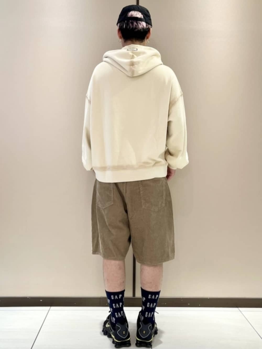 ホワイト系のパーカー、ブラウン系のその他パンツ、ブラック系のキャップを着用したメンズの春コーディネートの2枚目の写真
