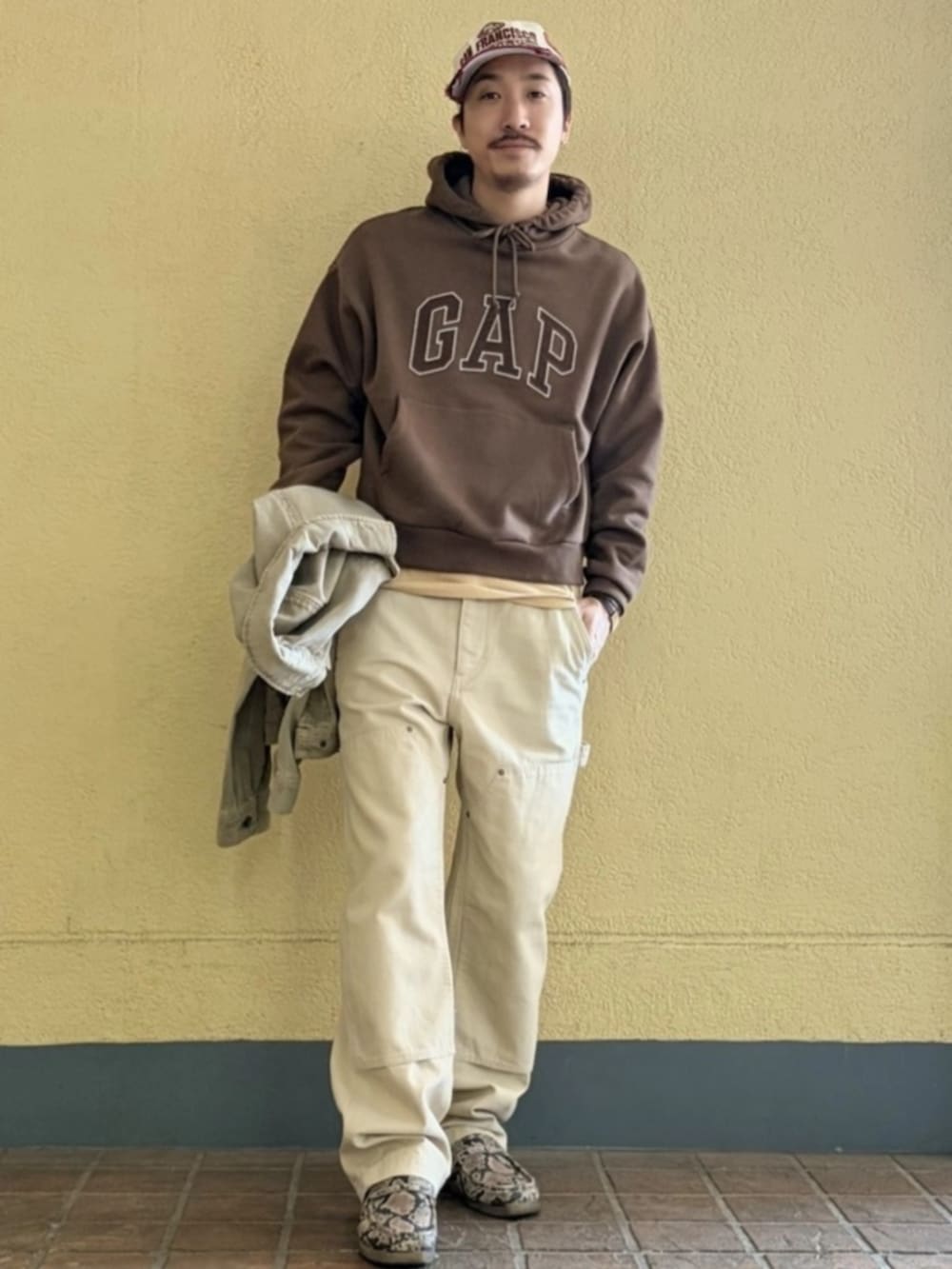 ベージュ系のTシャツ/カットソー、ベージュ系のその他パンツ、ブラウン系のパーカーを着用したメンズの春コーディネートの2枚目の写真