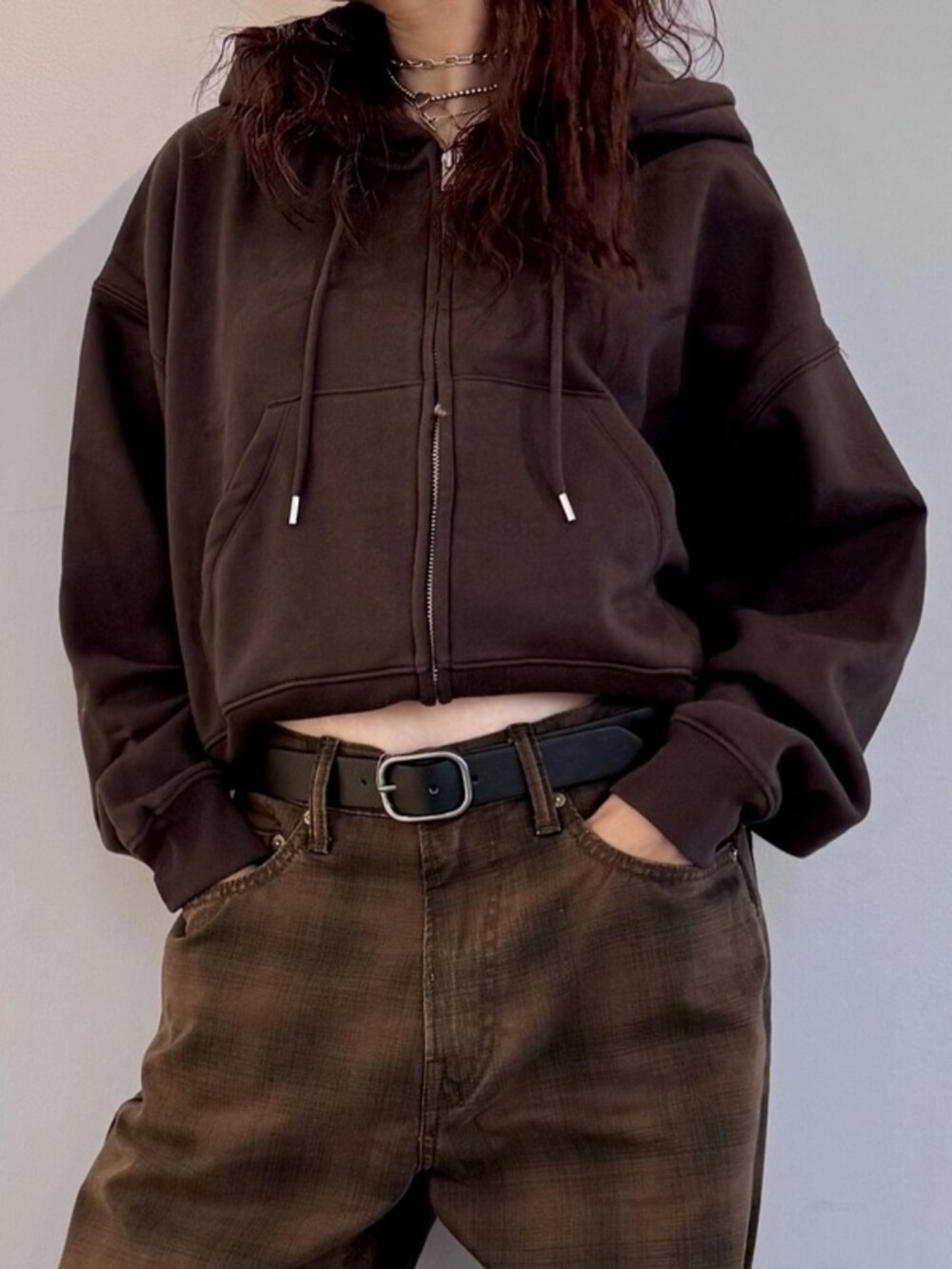 ブラウン系のデニムパンツ、ブラウン系のパーカー、ブラック系のベルトを着用したレディースの夏コーディネートの3枚目の写真