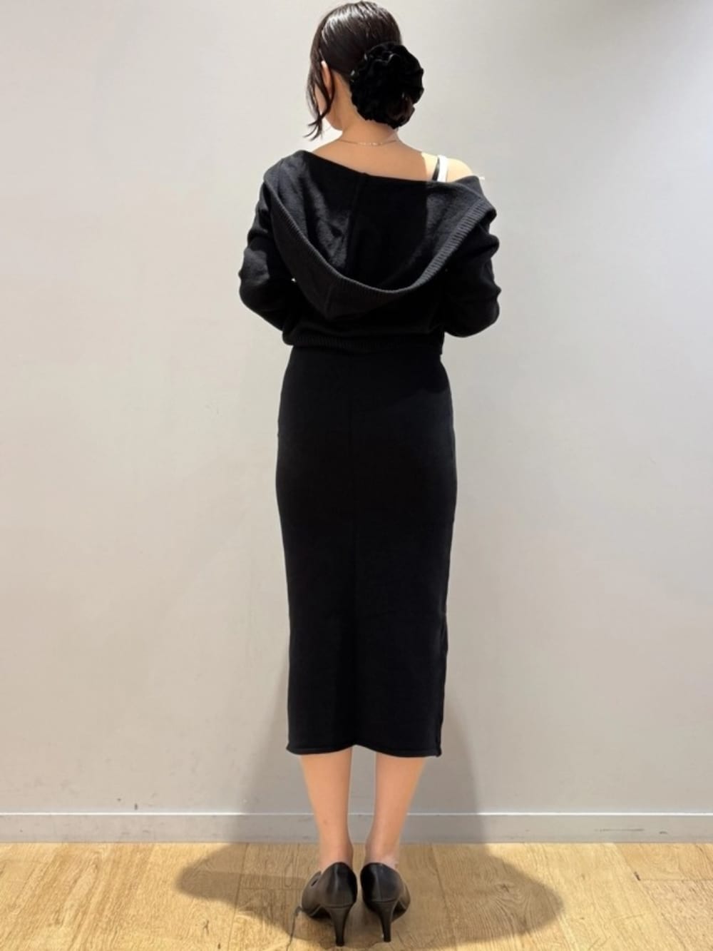 ブラック系のスカート、ブラック系のニット/セーター、ホワイト系のスポーツブラを着用したレディースの秋コーディネートの2枚目の写真