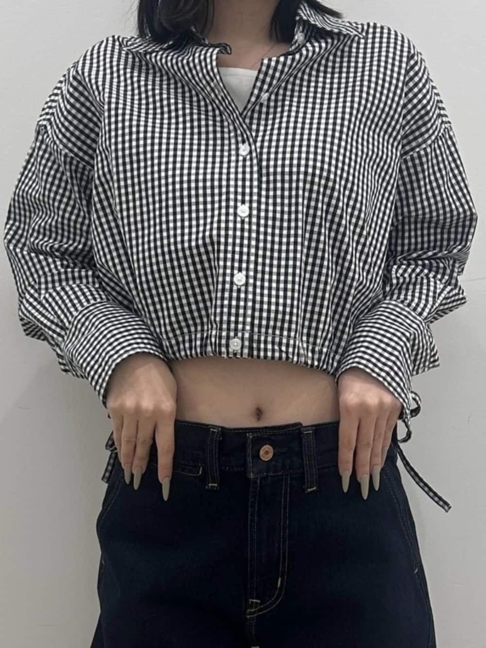 ホワイト系のTシャツ/カットソー、ブラック系のシャツ/ブラウス、ブルー系のデニムパンツを着用したレディースの冬コーディネートの3枚目の写真