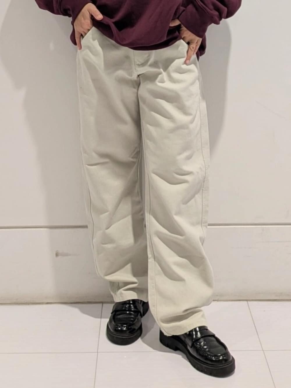 ホワイト系のチノパンツ、レッド系のスウェット、ブルー系のキャップを着用したレディースの秋コーディネートの4枚目の写真