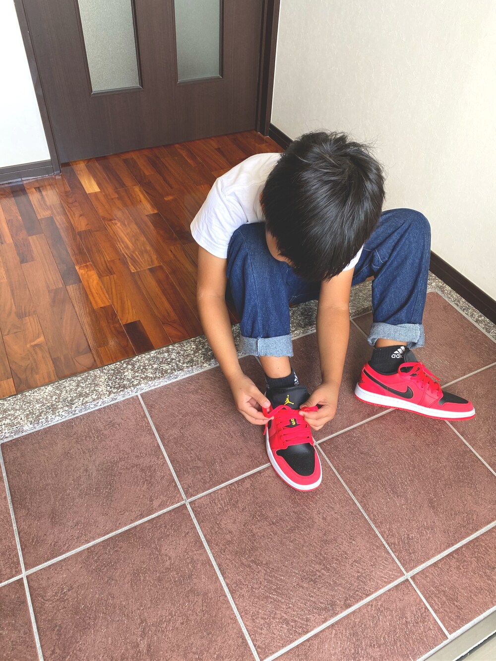 レッド系のスニーカーを着用したキッズの秋コーディネートの4枚目の写真