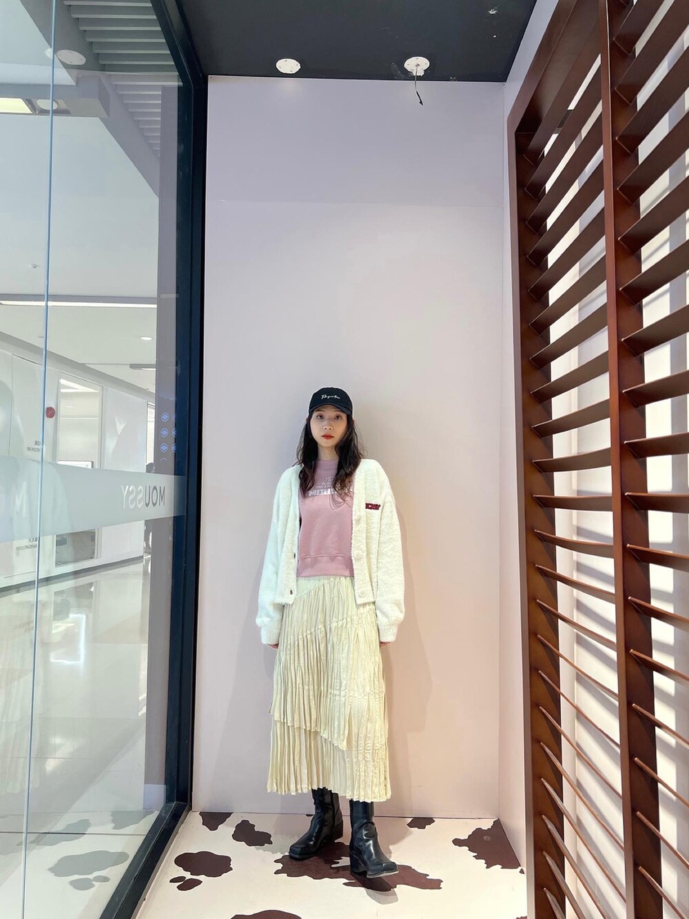 ベージュ系のスカート、ピンク系のニット/セーターを着用したレディースの春コーディネートの3枚目の写真