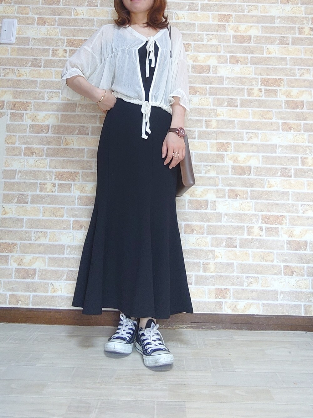 ブラック系のスカート、ホワイト系のシャツ/ブラウス、ブラック系のキャミソールを着用したレディースの夏コーディネートの2枚目の写真