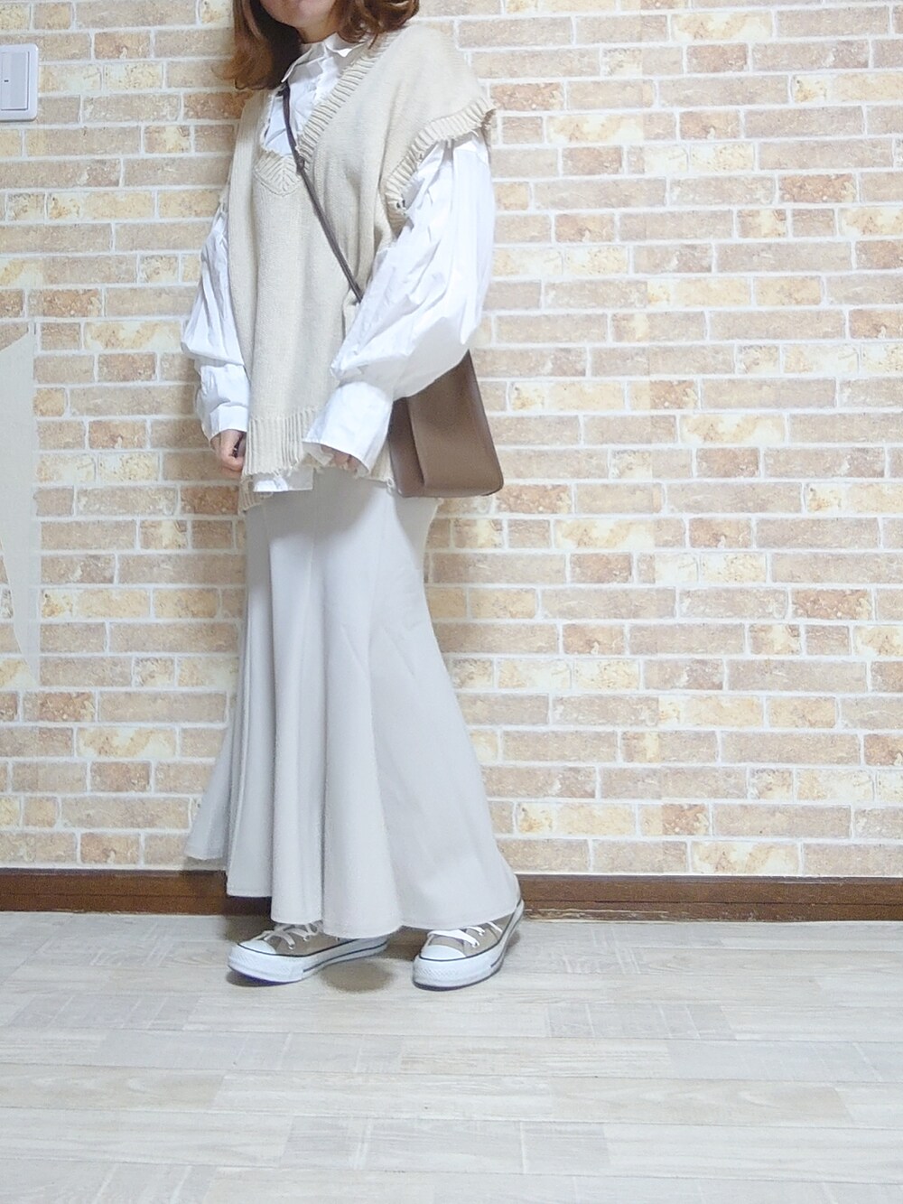 ベージュ系のスカート、ホワイト系のトップス、ホワイト系のシャツ/ブラウスを着用したレディースの春コーディネートの3枚目の写真