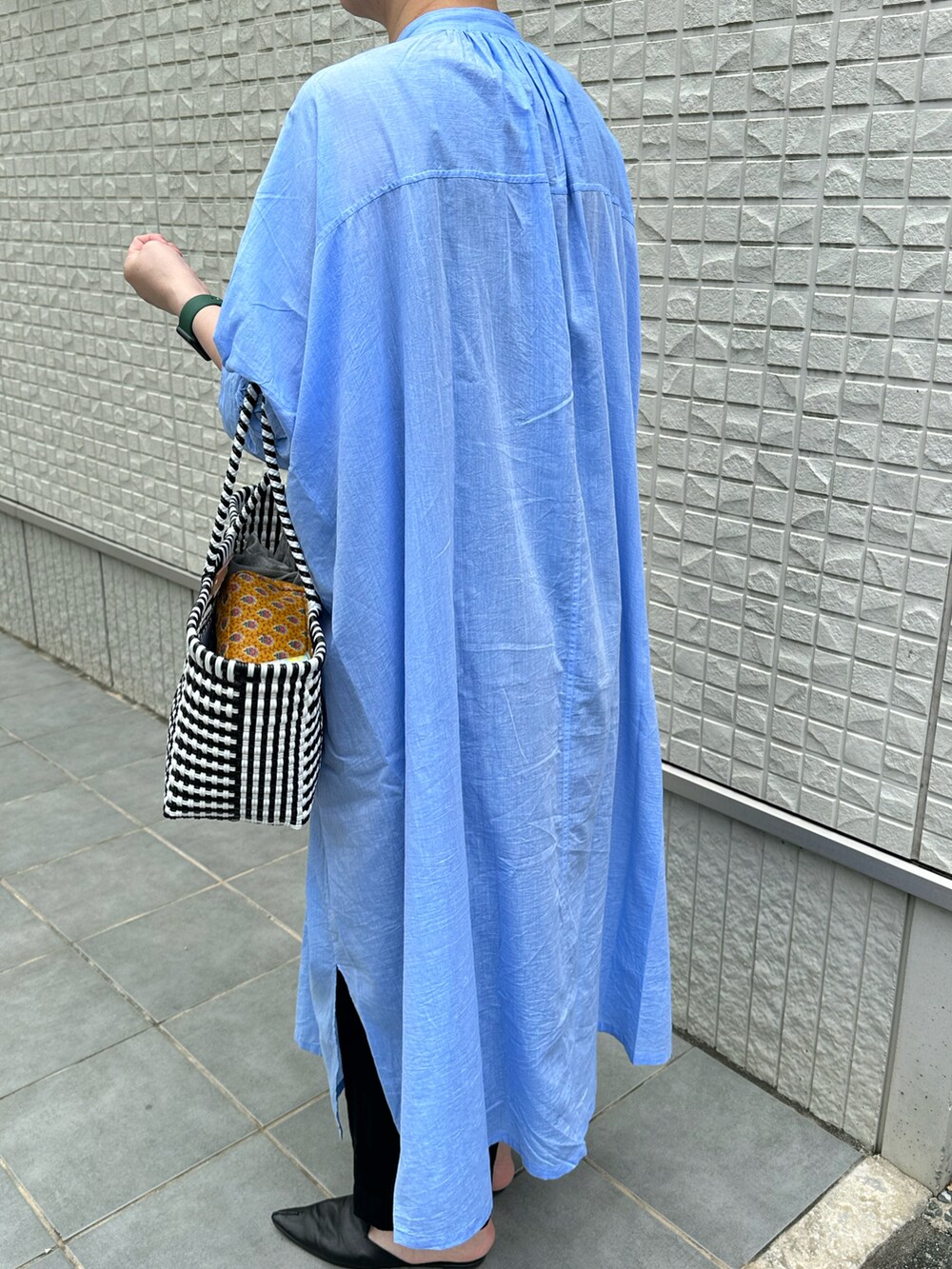 ブルー系のシャツワンピースを着用したレディースの夏コーディネートの2枚目の写真