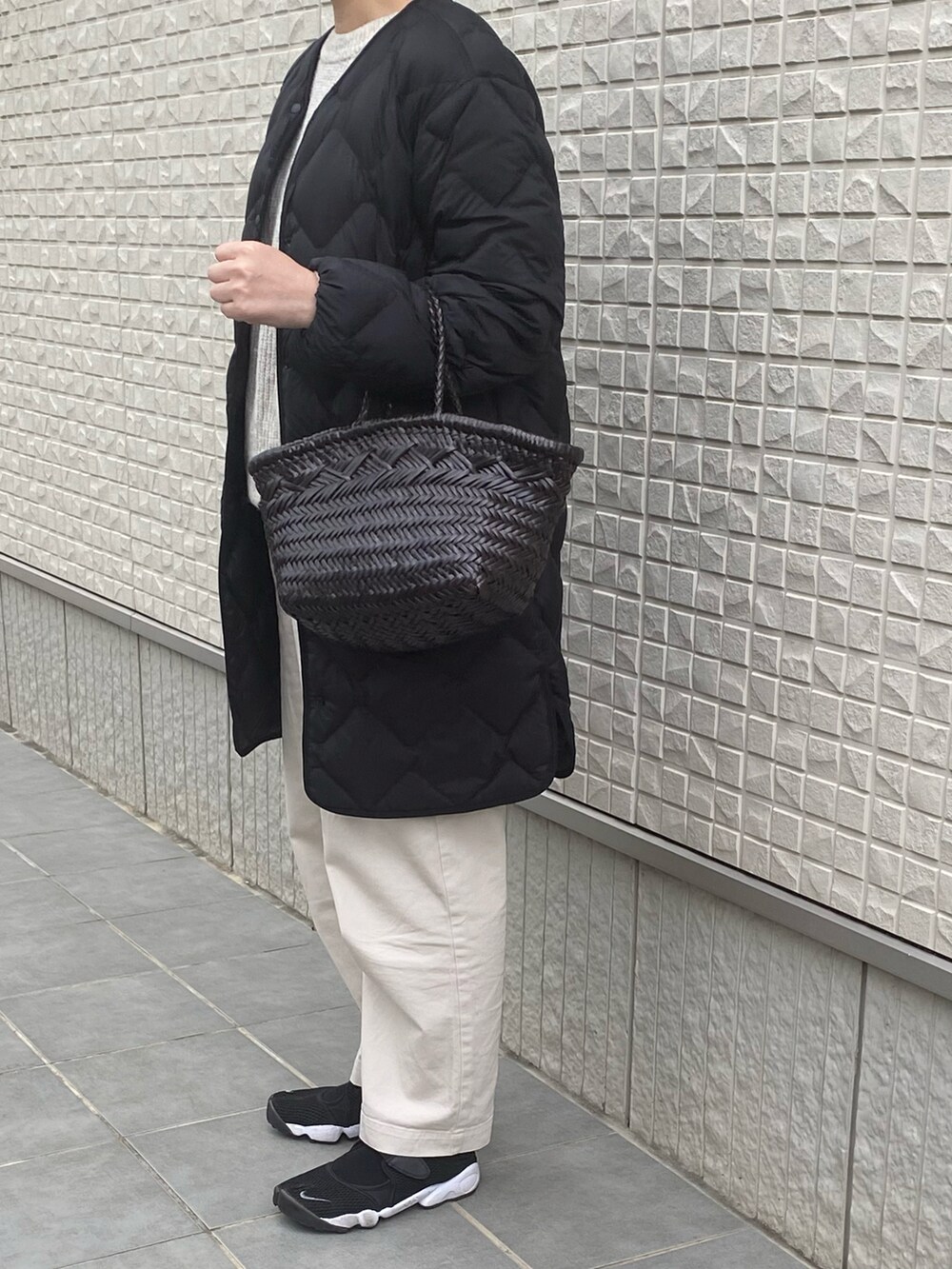 ベージュ系のチノパンツ、ベージュ系のニット/セーター、ブラック系のダウンジャケット/コートを着用したレディースの冬コーディネートの2枚目の写真