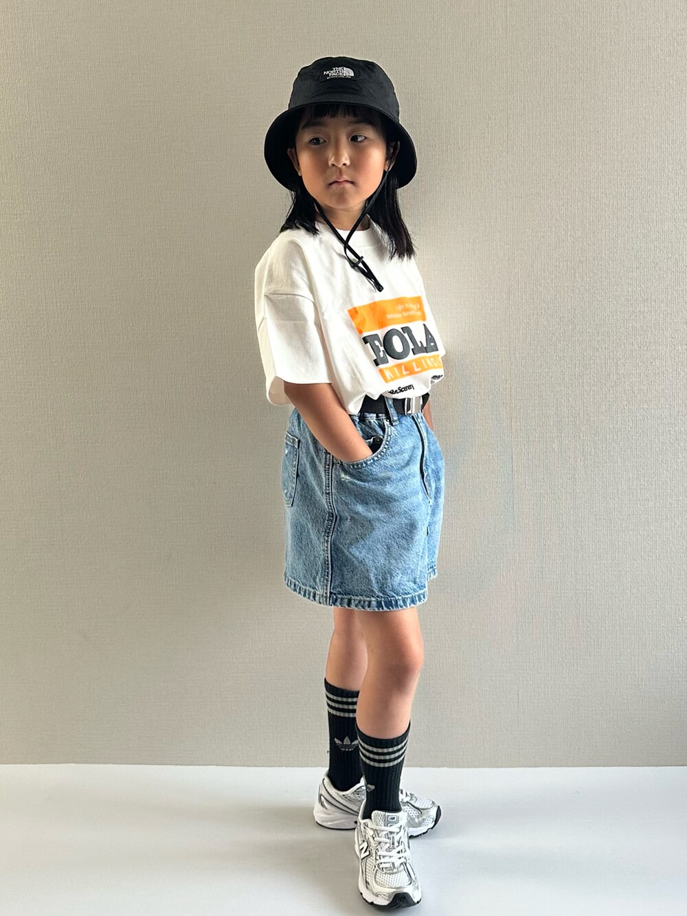 ホワイト系のTシャツ/カットソー、ブルー系のデニムスカート、ホワイト系のスニーカーを着用したキッズの夏コーディネートの2枚目の写真