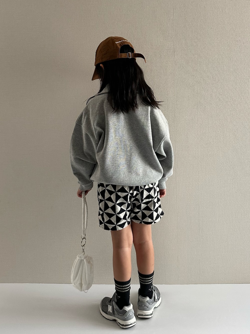 グレー系のスウェット、グレー系のその他パンツ、ホワイト系のショルダーバッグを着用したキッズの秋コーディネートの3枚目の写真