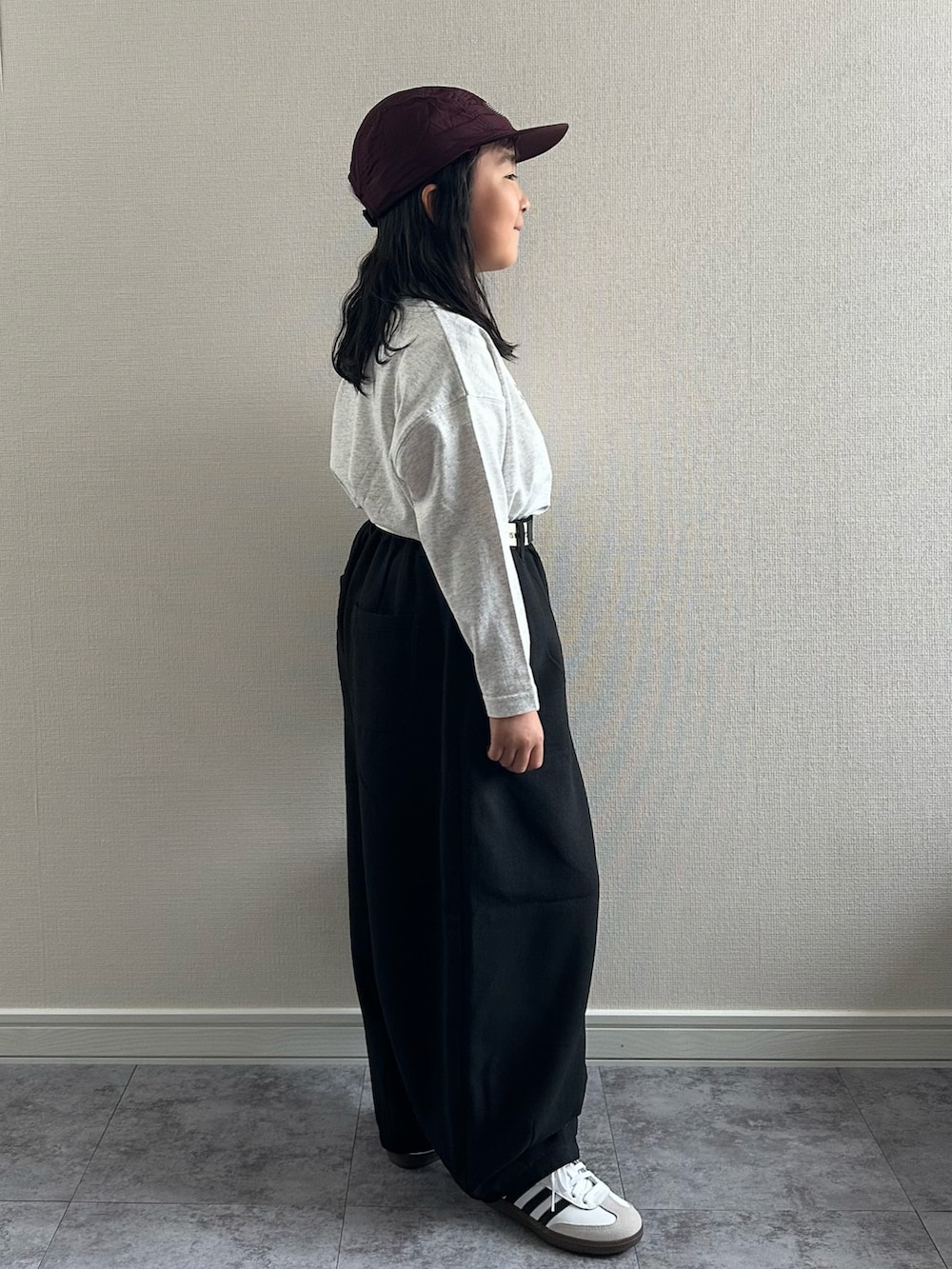 グレー系のTシャツ/カットソー、ブラック系のその他パンツ、レッド系のショルダーバッグを着用したキッズの秋コーディネートの2枚目の写真
