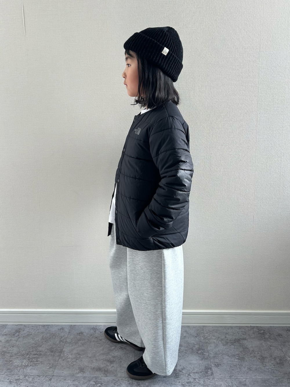 ブラック系のスニーカー、ホワイト系のTシャツ/カットソー、グレー系のスウェットパンツを着用したキッズの冬コーディネートの2枚目の写真