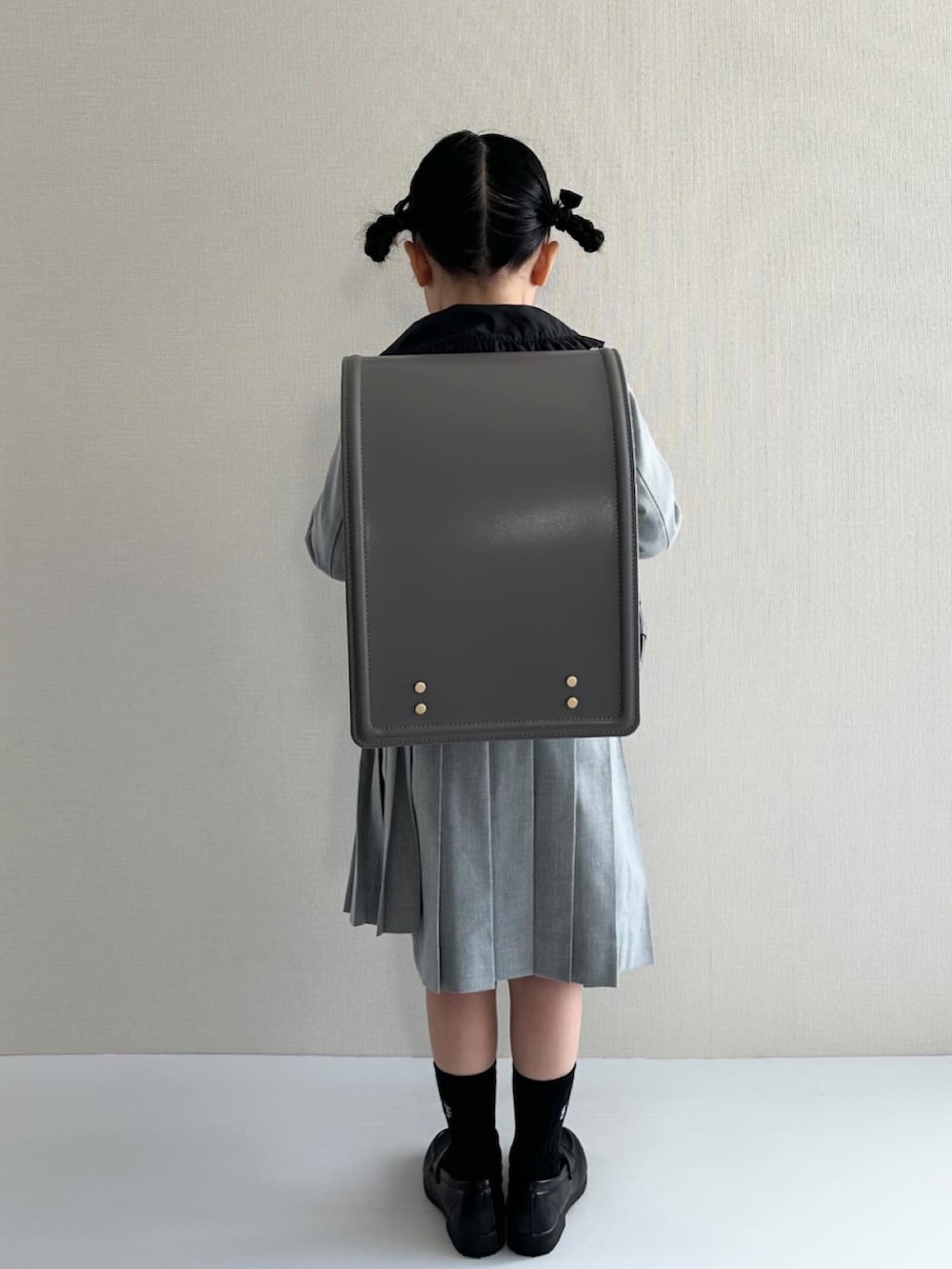 ブラック系のシャツ/ブラウス、グレー系のスーツジャケット、グレー系のスカートを着用したキッズの春コーディネートの3枚目の写真