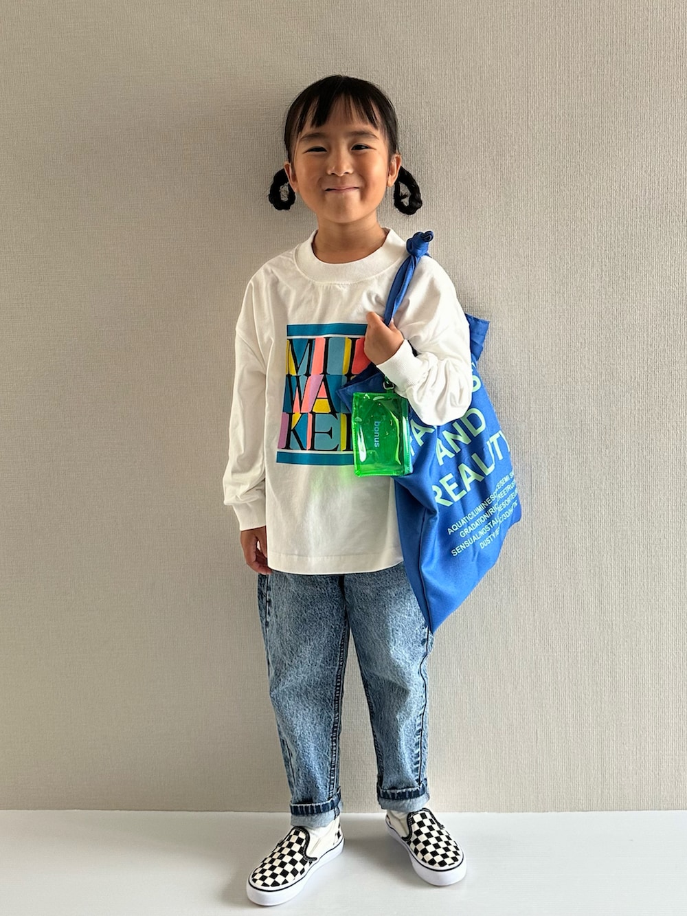 ホワイト系のTシャツ/カットソー、ブルー系のデニムパンツ、ブルー系のトートバッグを着用したキッズの秋コーディネートの3枚目の写真