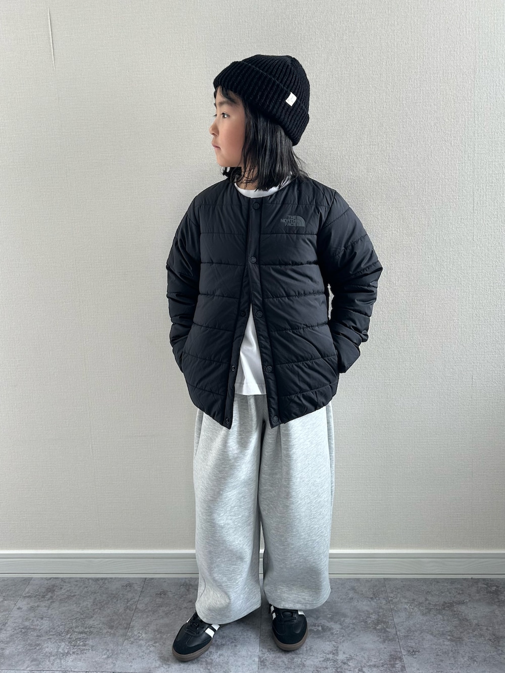 ブラック系のスニーカー、ホワイト系のTシャツ/カットソー、グレー系のスウェットパンツを着用したキッズの冬コーディネートの5枚目の写真
